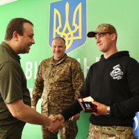 Начальник ОВА Сергій Борзов вручає військовослужбовцю нагороду