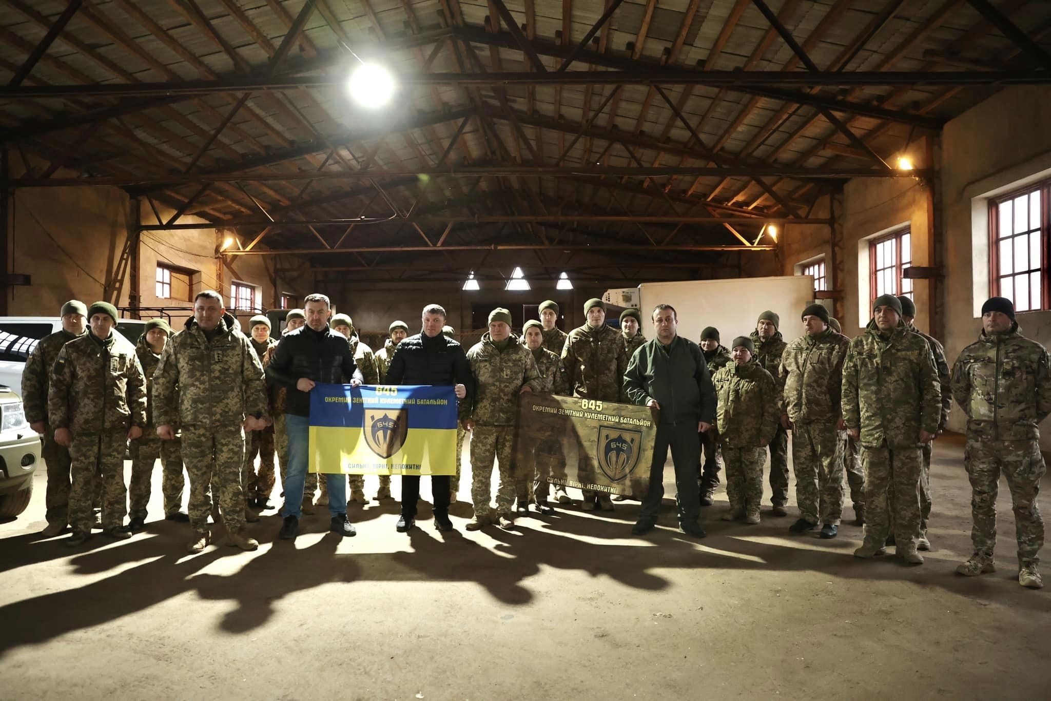 спільне фото Начальника ОВА Сергія Борзова та військових, які тримають прапори бригади 