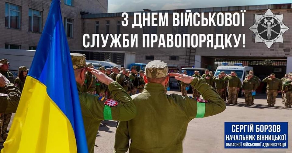 військові стоять біля Прапора України 