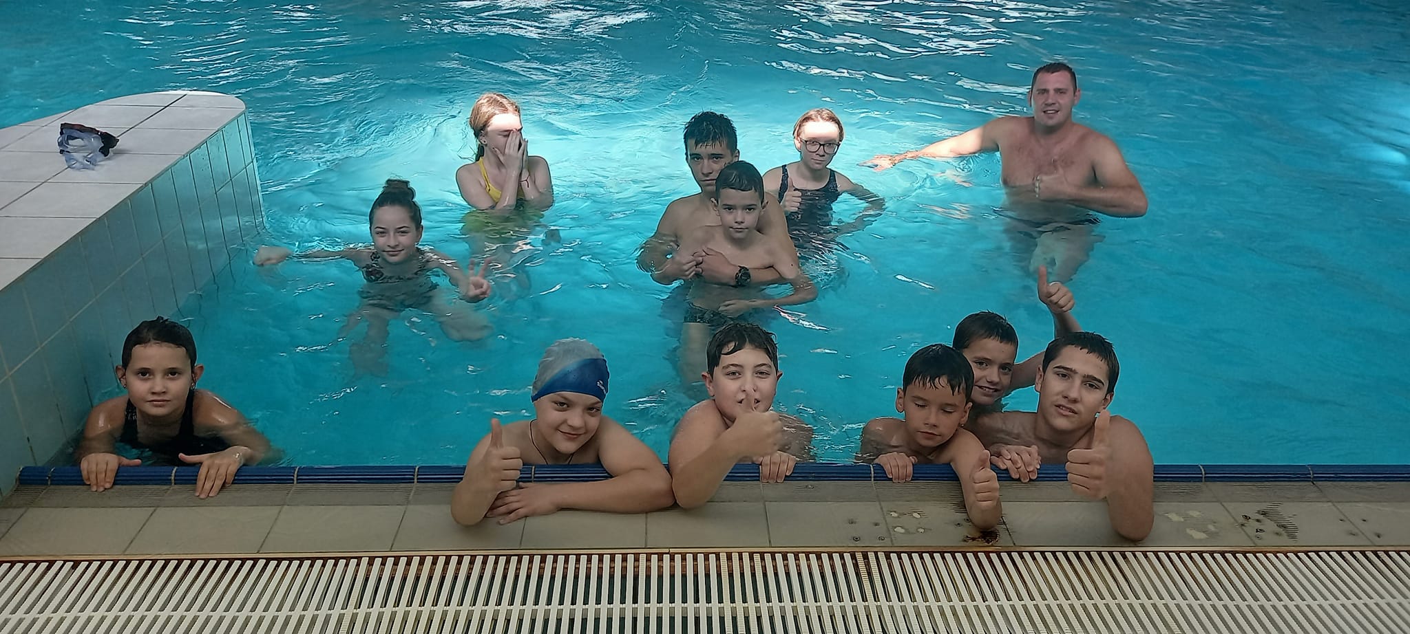 Група дітей купаються в басейні