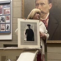 Жінка тримає у руках портрет архітектора Григорія Артинова