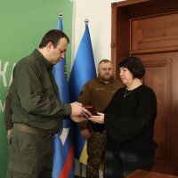 Начальник ОВА Сергій Борзов вручає нагороду родині захисника