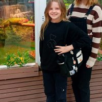 двоє дівчаток стоять біля тераріума з ігуаною