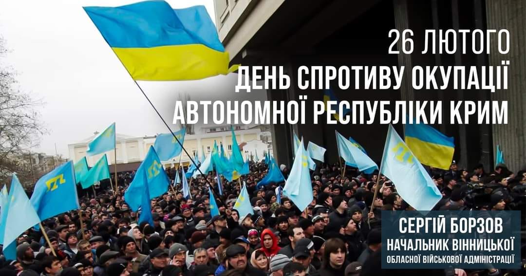 Люди, які тримають в руках кримськотатарські прапори
