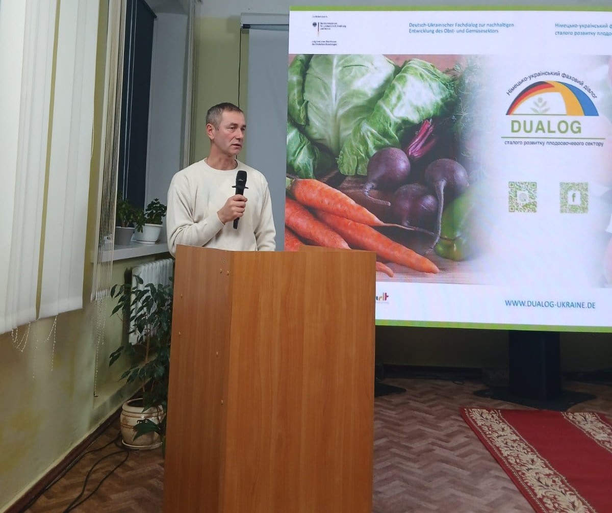 За трибуною виступає заступник директора Департаменту агропромислового розвитку, в руці тримає мікрофон