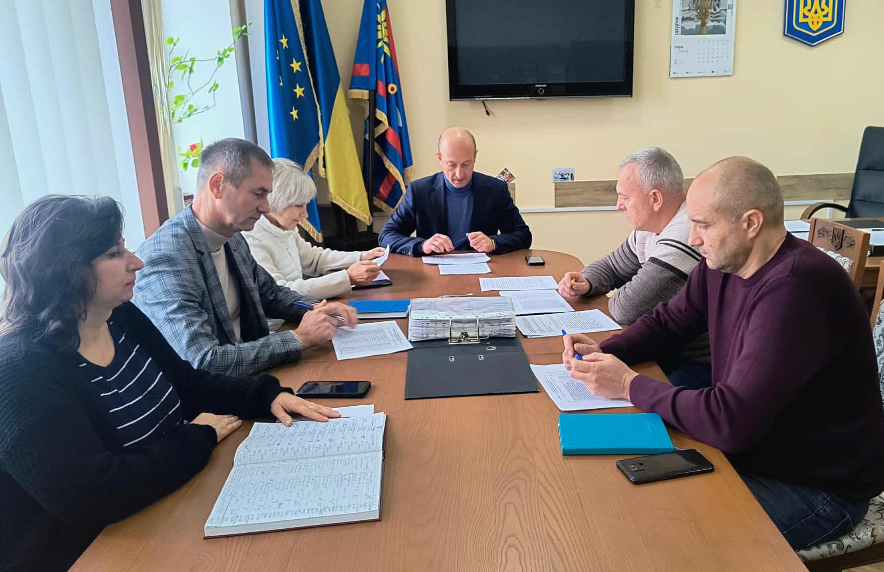 В кабінеті за робочим  столом сидят столом сидят члени комісії, перед ними  документи та записники