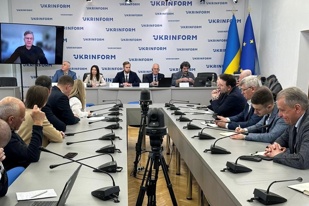 Люди сидят за робочими столами в залі засідань