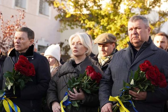 Люди тримають квіти під час меморіальної служби на честь жертв нападу.