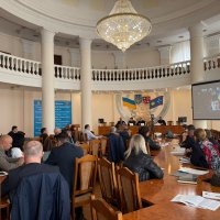 Учасники наради сидят в залі для засідань