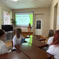 Фото з заходів. Люди в аудиторії сидять за столами