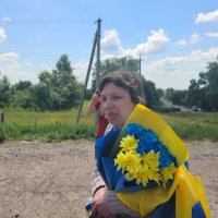 Жінка з прапором України та квітами