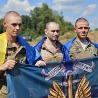 Українці, які повернулися з російського полону з прапором бригади
