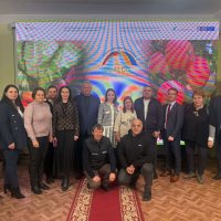 В залі  багато людей, які беруть участь у заході, позаду них банер з назвою проєкту