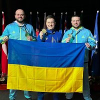 Спортсмени тримають український прапор
