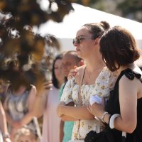 Дівчата вшановують пам’ять загиблих біля Меморіалу пам'яті жертв російського обстрілу міста 14 липня 2022 року