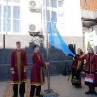 учасники заходу підіймають національний прапор кримськотатарського народу