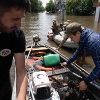 Люди у рятувальних шлюпках на затоплених вулицях Херсонщини