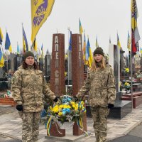 Покладання квіткової композиції до скульптури на Алеї Слави