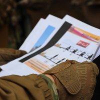 інструктор тримає  у руках інформаційні матеріали